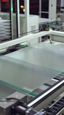 Robot makine içeride güneş paneli yapıyor. Modern bir fabrikada güneş pilleri üretme teknolojisi. Dikey video