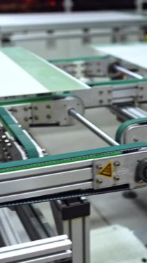 Güneş panelleri üretmek için otomatikleştirilmiş ekipmanların yakın çekim çalışmaları. Kapalı alanda yenilikçi teknolojileri olan modern bir fabrika. Dikey video