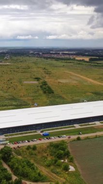 Doğadaki yenilikçi bitki üzerine havadan panoramik bir bakış. Kırsal bölgedeki modern fabrika binası. Hava görüntüsü. Dikey video
