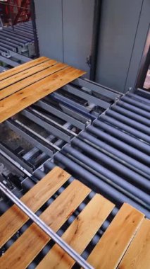 İçeride ahşap fabrikası var. Kaplamalı panellerle üretim hattı. Parke fabrikasındaki işçiler. Laminate döşeme konsepti. Dikey video