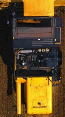 Tarım makineleri teması. Büyük modern sarı yukarıdan birleşiyor. Dron 'dan seçici odaklanma. Dikey video