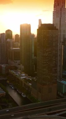 Parlak güneş muhteşem Chicago, Illinois, ABD 'nin üzerinde parlıyor. Batan güneşin ışınlarında muhteşem gökdelenler. Üst Manzara. Dikey video