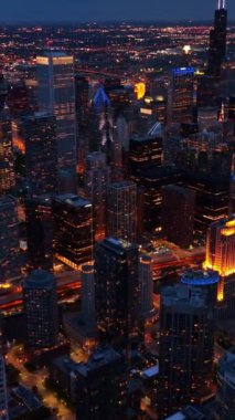 Akşam Chicago şehir merkezinin göz alıcı manzarası. Yukarıdan görünen ışıklarda çarpıcı bir metropol. Dikey video