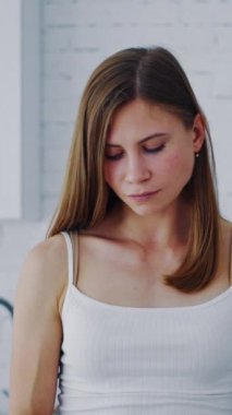 Sıcak mutfağında turuncu elbiseli genç bir kadın. Kapalı alandaki kadınların elindeki sağlıklı meyve. Sulu portakalın yarısını tutan güzel bir kadın. Diyet konsepti. Dikey video