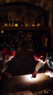 Karanlık bir odada iki elf içinde parlayan büyük sandığı açar. Sihirli kitabı alan peri karakterleri kapalı alanda Xmas arka planında tahta sandıktan. Dikey video