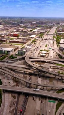 Yol döngüleri ve birden fazla otomobilin geçtiği kavşaklar. Chicago 'nun düşük mimarisi. Hava görüntüsü. Dikey video