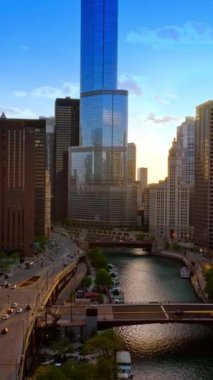 Chicago şehir merkezinde fütüristik mimarisi var. Nehir ve köprüler geçiyor, suda birden fazla yat var. Üst Manzara. Dikey video