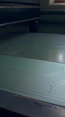 Buzlu cam parçası çizgilerle süslenmiş. Fotoğraf, gelecekteki kapıya otomatik alet makinesi tarafından uygulanır. Dikey video