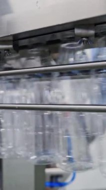Boş plastik şişeler konveyör hattında. Şişe üretim hattı. Modern süt fabrikasında sıvı ürünler için plastik şişeler. Dikey video