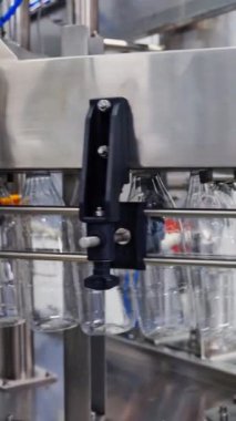 Süt şişeleri otomatik üretim hattında. Robot fabrikasında mandıra üretimi. Boş şişeler üretim hattında sütle doluyor. Dikey video
