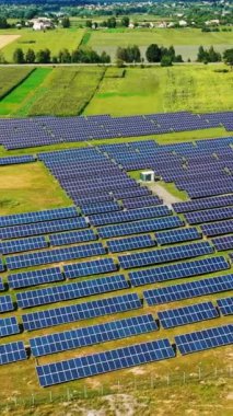 Kırsal bölgedeki büyük güneş sistemi bitkisi. Güneşli bir günde güneş panelleri ve yenilenebilir enerji çiftliğinin havadan görünüşü. Dikey video