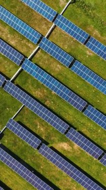 Güneş enerjisi santralinin havadan görünüşü. Alternatif temiz elektrik. Sahadaki güneş panellerinin drone görüntüsü. Aşağı doğru hareket edin. Dikey video