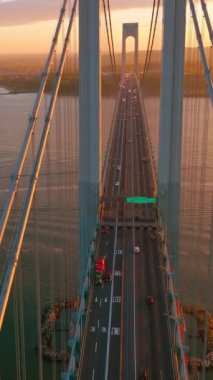 Ulaşım için otoyolları olan güzel bir köprü. Üst Manzara. Nehrin üzerinde batan güneş ışınlarıyla devasa bir yapı. Dikey video