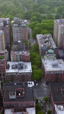 Gündüzleri farklı evlerin olduğu bir yerleşim yeri. Bölge 'nin hemen arkasındaki güzel yeşil park ve nehir. Hava görüntüsü. Dikey video