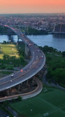 New York 'ta iki köprü arasında güzel bir yer. Şehir akşam ışıklarını yakıyor. Gün batımında pembe güneşin altında devasa şehir manzarası. Dikey video