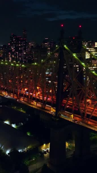 美丽地突出了皇后桥在夜间 无人机在充满活力的城市上空盘旋纽约数十亿的灯光 垂直录像 — 图库视频影像