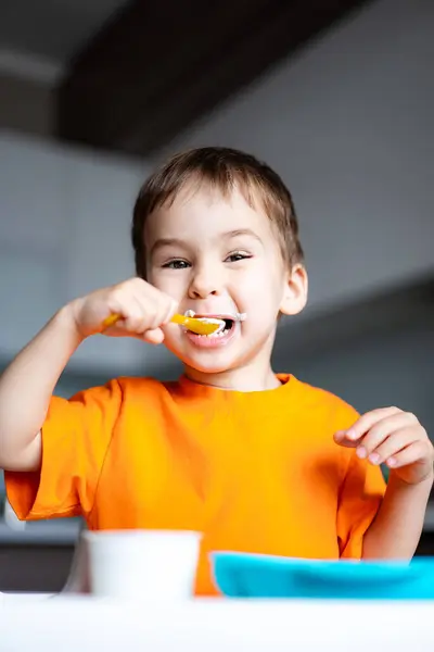 Young Boy Eating Bowl Cereal Spoon Smiling Enjoying His Meal Fotografie de stoc