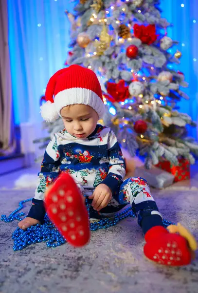 Lille Barn Sidder Gulvet Foran Juletræ Barnet Har Rød Hat Stock-billede