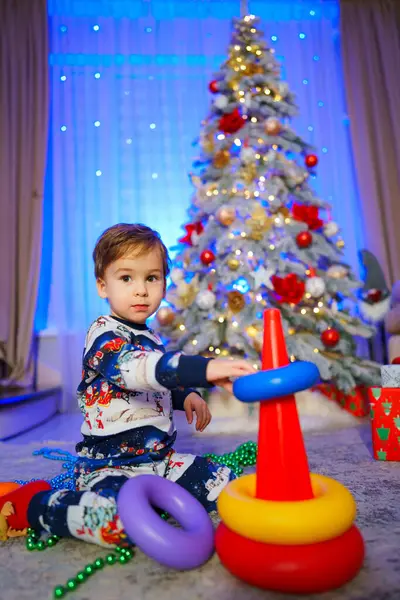 Young Boy Sitting Front Christmas Tree Playing Stack Rings Scene Fotografie de stoc