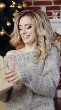 Hediye Kutusu Yeni Yıl Kutlaması. Şöminenin yanında hediye kutusu olan çekici bir kadın.