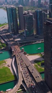 Chicago Liman Yat Kulübü 'nde çok sayıda tekne var. Göl kıyısından geçen yoğun bir otoyol. Deniz yeşili suların üzerinde yükselen gökdelenler. Dikey video