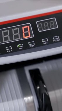 Cash money counting machine. Banknote counter are counting hundred dollar bills. Close-up Vertical video