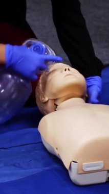 First medical help training equipment. Medical dummy lays on blanket . Practititoner puts oxygen mask. Educational courses for medics. Vertical video