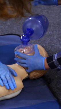 Medical dummy doll lays on blue blanket ready for training. First medical help with oxygen masks. First aid help. Vertical video