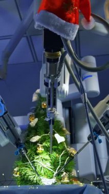 Gaze at the precise work of the Da Vinci system while decorating the fur-tree. Hi-tech robotic system in the modern surgery room. View from below. Vertical video