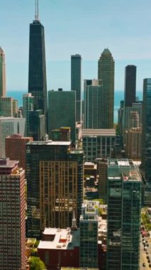 Chicago, Illinois 'in harika ve çeşitli binaları. İHA görüntüleri gökdelenlerin arka planında şehrin üzerinde uçuyor. Dikey video