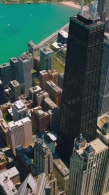 Michigan Gölü 'nün turkuaz suları. Gölün kıyısına görkemli gökdelenler inşa edildi. Hava görüntüsü. Dikey video