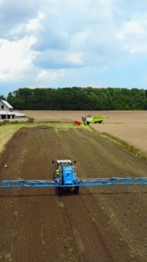 Çiftliğe Otomatik Sprey Spreyi. Dikey videoda mahsulleri sulayan kendinden tahrikli sprey.