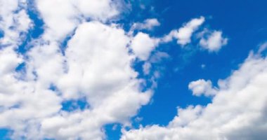 Yumuşak beyaz bulutların arkasına gizlenmiş masmavi gökyüzü. Kümülüs bulutları zaman ayarlı.