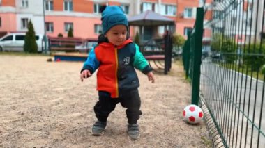 Oyuncu çocuk oyun parkına kum atıyor. Bebek dış dünyayı inceliyor..