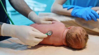Kafkasyalı yeni doğan yan yatırılır. Çocuk doktoru doğumdan sonra bebeğin kalbini ve ciğerlerini dinler. Kapat..