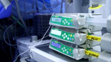 Akciğer solunum cihazının yanında çalışan infüzyon makineleri. Ameliyat sırasında modern ekipmanlar ameliyathanede. Bulanık arkaplan.