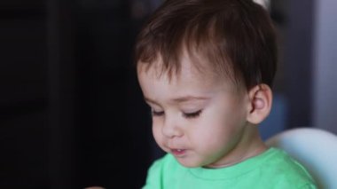 Anne, tatlı bebeğini kaşıkla besler. Anne çocuğun elindeki çatalı çevirir ve bebek kendini yer..