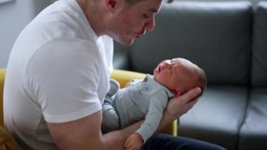 Küçük yeni doğmuş çocuk babasının ellerinde ağlıyor. Babası çocuğunu teselli etmeye çalışıyor..
