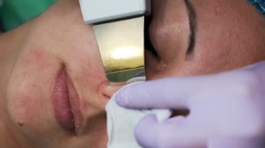 Deri kusurlarını ultrasonik fırçayla temizliyor. Güzellik uzmanı kozmetik aletini kadın burun deliklerinde gezdiriyor. Çok yakın çekim..