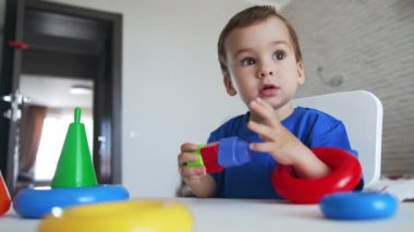 Bebek oyuncaklarla oynayarak renkleri ve şekilleri öğreniyor. Bebek oyun boyunca ders çalışıyor. Düşük açı görünümü.