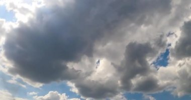 Yazın gökyüzünde kalın gri bulut oluşumu. Yağmurlu bulutlar güneşi kaplıyor. Düşük açı görünümü zaman ayarlı.