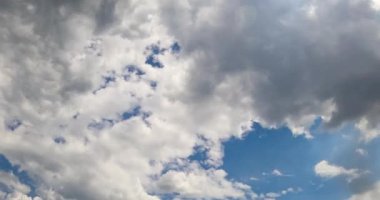 Atmosferde kabarık beyaz ve gri bulutlar var. Bulutların oluşumu düşük açılı açıdan. Zaman Uygulaması.