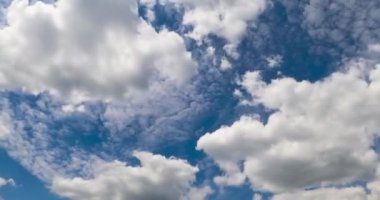 Atmosferde kabarık beyaz bulutlar oluşuyor. Arkaplanda ışık tabakası bulutları. Düşük açı. Zaman Uygulaması.