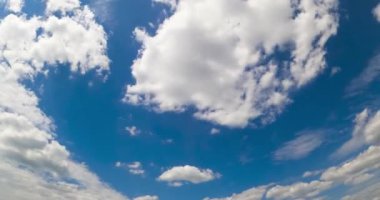 Yumuşak kabarık bulutlarıyla inanılmaz bir yaz gökyüzü. Arka planda Stratus bulutları uçuşuyor. Düşük açı. Zaman Uygulaması.