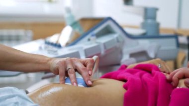 Ultrason dönüştürücü, bir hastanın hamile karnı tarafından yavaşça hareket ettirilir. Bebek kontrolünün rahim içi gelişimi.