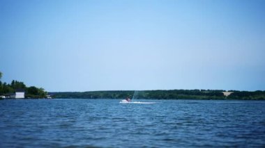 Güneşli bir günde nehirde jet ski bisikleti süren insanlar. İki su motorcusu yavaşça limana yaklaşıyor..