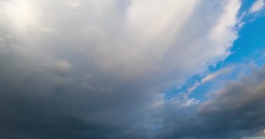 Mavi yaz gökyüzünde büyük gri bulut. Yağmur bulutları atmosferde birikiyor. Düşük açı. Zaman Uygulaması.