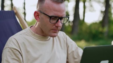 Doğada uzaktan kumandalı çalışan meşgul bir adam. Gözlüklü serbest çalışan bazı zorluklar yaşıyor..