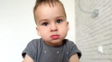 Sakin ol beyaz çocuk kameraya ciddi ciddi bakıyor. İkinci bir çocuk gülümsemeye ve zıplamaya başlar. Kapat..