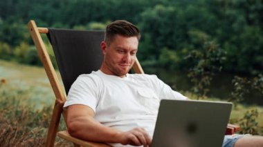 Kafkas sakallı, orta yaşlı bir adam laptopta çalışırken dikkatini dağıtıyor. İşadamı bir şey düşünürken kafasını çevirir..